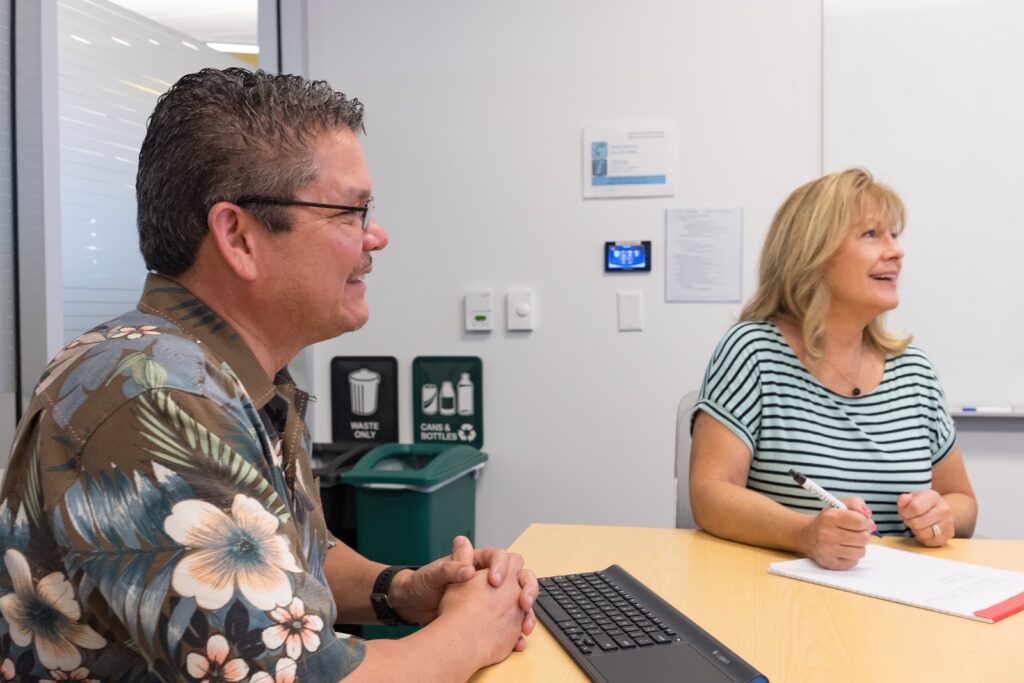 Two UCPath employes working at a table.